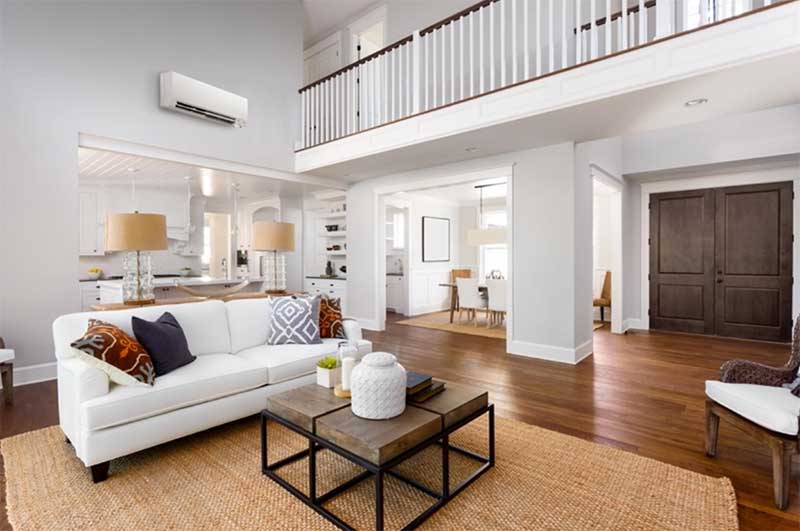 View of a living room with a heat pump on the wall
